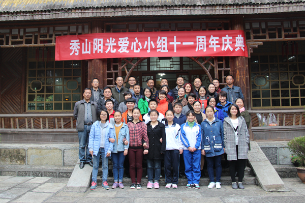 供电公司职工瞿秀泉在秀山县高级中学体育馆旁,等着资助对象胡泽兴