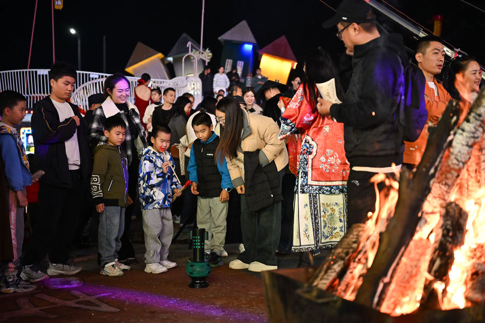 图为小朋友们在“穿越时空奇妙夜”上体验投壶。 记者 何蓬磊 摄 图为小朋友们在“穿越时空奇妙夜”上体验投壶。 记者 何蓬磊 摄
