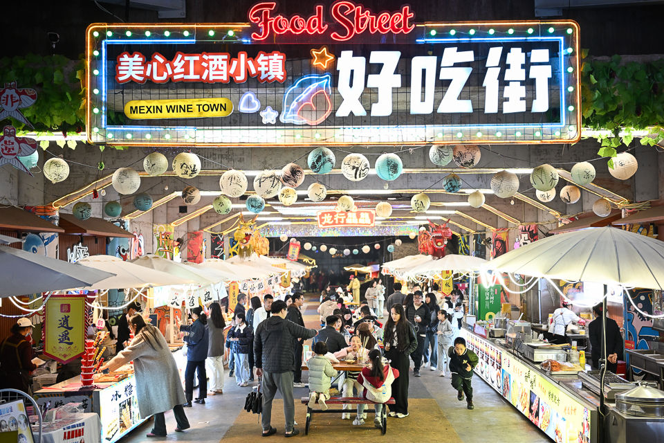 图为游客在“穿越时空奇妙夜”的好吃街里选购美食。 记者 何蓬磊 摄 图为游客在“穿越时空奇妙夜”的好吃街里选购美食。 记者 何蓬磊 摄