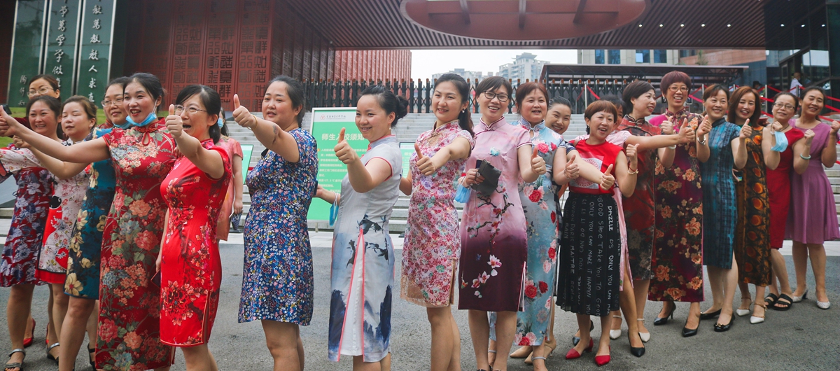 寓意“旗开得胜”！在重庆市育才中学考点外，身穿旗袍的妈妈们为考生加油鼓劲。